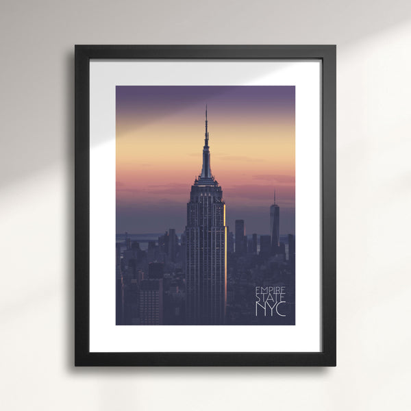 Framed artwork of the Empire State Building at sunset with 'Empire State NYC' text.