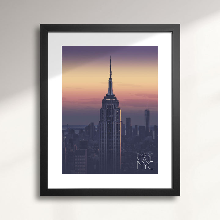 Framed artwork of the Empire State Building at sunset with 'Empire State NYC' text.