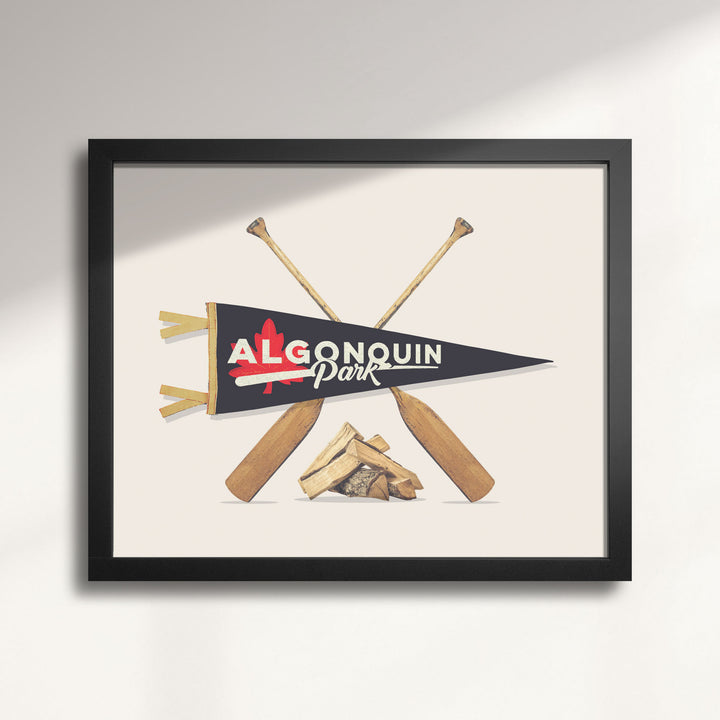 Framed artwork with Algonquin Park pennant and paddles on a beige background