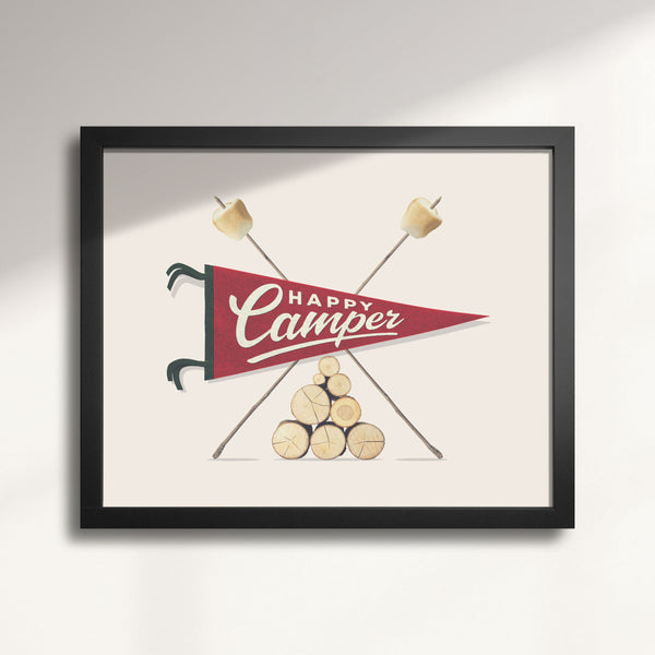 Framed artwork with 'Happy Camper' design featuring a red banner, crossed marshmallow sticks, and stacked logs on a light background, titled Happy Camper Pennant